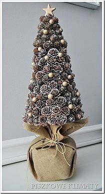 a small christmas tree made out of pine cones and burlocks on a table