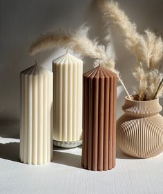 three tall vases sitting next to each other on a table