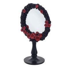 a mirror with roses on it sitting on top of a black stand in front of a white background