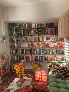 a living room filled with furniture and lots of books on the shelves in front of it