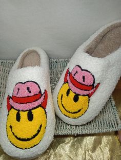 Stay cozy and put a smile on your face with these Smiley Face House Slippers! These slippers will keep your feet warm and provide you with hours of comfort. Slip them on and have fun! Get ready to embrace the joy of a smiley face. Playful Winter Slip-on Slippers, Cute Round Toe Slippers For Leisure, Winter Lounging Slippers With Round Toe, Cute Round Toe Slippers For Loungewear, White Winter Home Slippers, Cute White Slippers For Leisure, Fun Round Toe Winter Slippers, Fun Round Toe Slippers For Winter, Fun White Slip-on Slippers