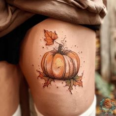 a woman's thigh with a pumpkin tattoo on it