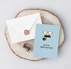 a card with an envelope and some type of mustache on it next to a penny