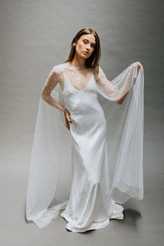 Untamed Petals Pismo Cape is an exquisite tulle cape hand-beaded with pearls, crystals, + beads! A pearl button closure adds the finishing touch to this elegant cape. Untamed Petals Pismo Cape is Ivory in color and is 'one size fits most'. Bride Cape, Fitted Wedding Gown, Cape Veil, Wedding Cloak, Tulle Cape, Vintage Veils, Wedding Cape, Bridal Wrap, Bridal Cape