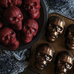 there are many skulls in the pan next to some muffins that have been baked