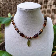 A Unique And Earthy Bohemian Gemstone And Glass Beaded Necklace. Crafted With Various Types Of Unique Green And Brown Czech Glass Beading, Green Serpentine Stone Chips, 4 Mm Polished Unakite Stone, Natural Coconut Shell Heishi Beading, Polished Mahogany Obsidian Stone, And A Beautiful Dark Green Pressed Czech Glass Oval Pendant At The Center. Handmade By Me, One Of A Kind. Hypoallergenic Stainless Steel Chain And Clasp. Nickel Free. Total Length: 16 Inches Length Of Chain: 14 Inches Extender Length: 1.5 Inches. If You Require A Longer Extension Chain To Ensure A Proper Fit, Please Let Me Know! Just Shoot Me A Message. Width & Length Of Glass Pendant: 7 Mm X 20 Mm Cla Bohemian Teardrop Glass Jewelry, Handmade Bohemian Glass Crystal Necklaces, Bohemian Glass Crystal Necklaces For Jewelry Making, Handmade Bohemian Glass Crystal Necklace, Handmade Glass Crystal Necklace In Bohemian Style, Bohemian Brown Glass Necklaces, Bohemian Brown Glass Beaded Necklaces, Bohemian Brown Glass Beaded Necklace, Adjustable Brown Czech Glass Necklace