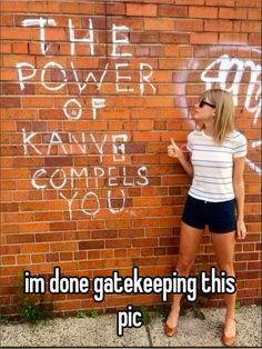 a woman standing in front of a brick wall with graffiti on it and the words i'm one gate keeping this pic