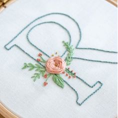 a close up of a embroidery on a piece of cloth with the letter q in it