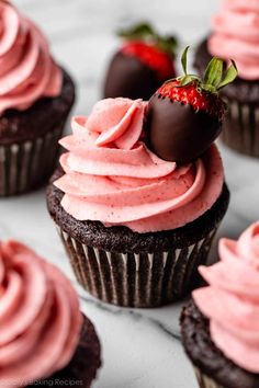 chocolate cupcakes with strawberry frosting and strawberries on top