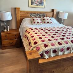 a bed with a crocheted bedspread and pillows on top of it