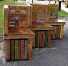 several books are stacked on top of each other in front of a park bench that is made out of wooden planks