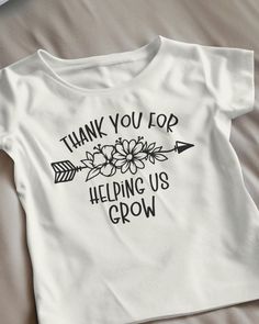 a t - shirt that says thank you top helping us grow with an arrow and flowers