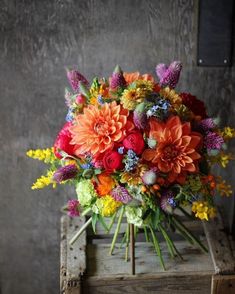 a bouquet of flowers sitting on top of a wooden box