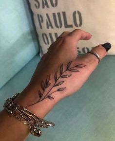 a woman's hand with a tattoo on it and a chain around her wrist