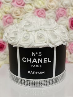 a black and white box with flowers on it sitting in front of a flower wall