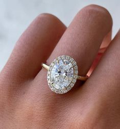 a woman's hand with a diamond ring on top of her finger and an engagement band