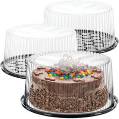 three clear cake cases with chocolate frosting and candy toppings on each one side