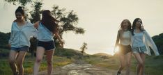 three young women walking down a dirt road