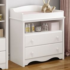 a baby crib with two drawers and a stuffed animal