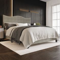 a bedroom with black walls and white bedding in the center, along with wooden flooring