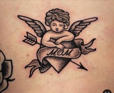 an angel tattoo on the back of a woman's stomach with arrows around it