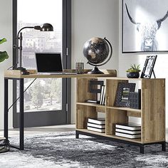 a desk with a laptop on top of it in front of a window and a plant