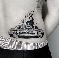 a police car with flames on the back of its body is seen in this tattoo