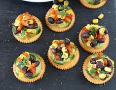 many small crackers with different types of food on them