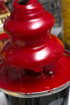 a red sauce pot sitting on top of a white table