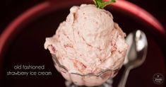 a scoop of ice cream with a green leaf on top sits in front of a fork