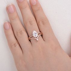 a woman's hand with a diamond ring on top of her finger and the other hand holding it