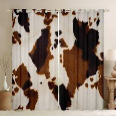 a cow print curtain hanging on the side of a wall next to a lamp and table