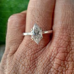 a woman's hand with a diamond ring on it