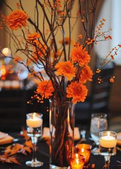 a vase filled with flowers and candles on top of a table