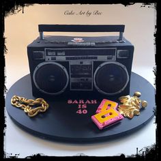 a cake made to look like a boombox with chains around it and cassette tape recorder on top