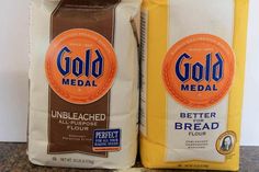 two bags of unbleached bread sitting on top of a counter next to each other