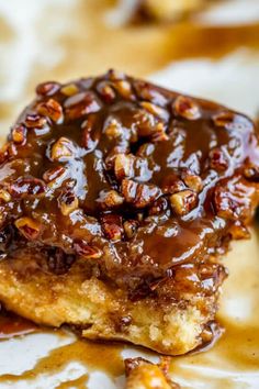 a piece of cake covered in caramel and pecans on top of wax paper