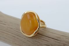 Experience the timeless beauty of our Authentic Butterscotch Amber Ring, a radiant reflection of nature's elegance. Set in gold-plated Sterling Silver, the fusion of gold and amber creates a stunning contrast, exuding warmth and sophistication. With its adjustable design, this ring offers both style and comfort. Born from ancient forests and preserved over millennia, amber holds within it the magic of nature's enduring legacy, making each piece a cherished symbol of beauty and grace. Amber dimen Elegant Yellow Cabochon Rings, Elegant Adjustable Yellow Ring, Elegant Yellow Adjustable Ring, Fine Jewelry Amber Ring With Polished Finish, Fine Jewelry Amber Rings With Polished Finish, Amber Ring With Polished Finish Fine Jewelry, Amber Rings With Polished Finish Fine Jewelry, Amber Ring Gold, Ancient Forest