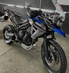 a blue and black motorcycle parked in a garage