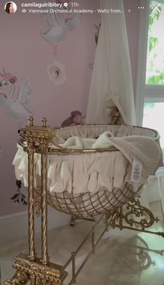 a baby's crib in the corner of a room with pink wallpaper