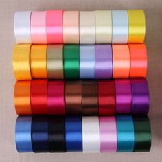 many colors of satin ribbons are stacked on top of each other