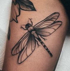 a black and white photo of a dragonfly tattoo