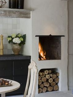 a kitchen with a table and chairs next to a fire place in the fireplace area