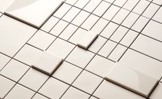 white tiles with squares and rectangles are arranged in a pattern on the floor