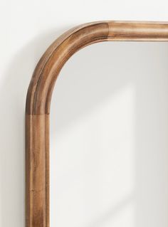 a wooden frame mirror hanging on the wall