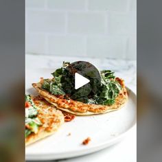 two flatbread pizzas with spinach and cheese on them