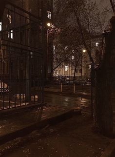 an empty city street at night with no one on the sidewalk or in the rain