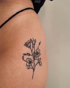 a woman's thigh with a flower tattoo on it