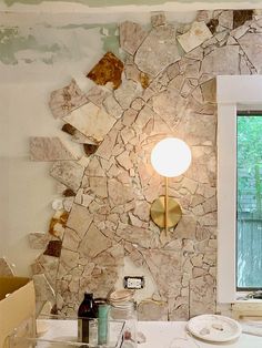 a bathroom with a sink, toilet and mirror that has broken tiles on the wall