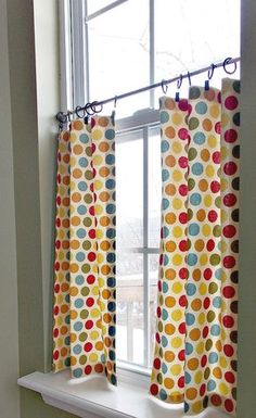 a window with polka dot curtains hanging from it's side